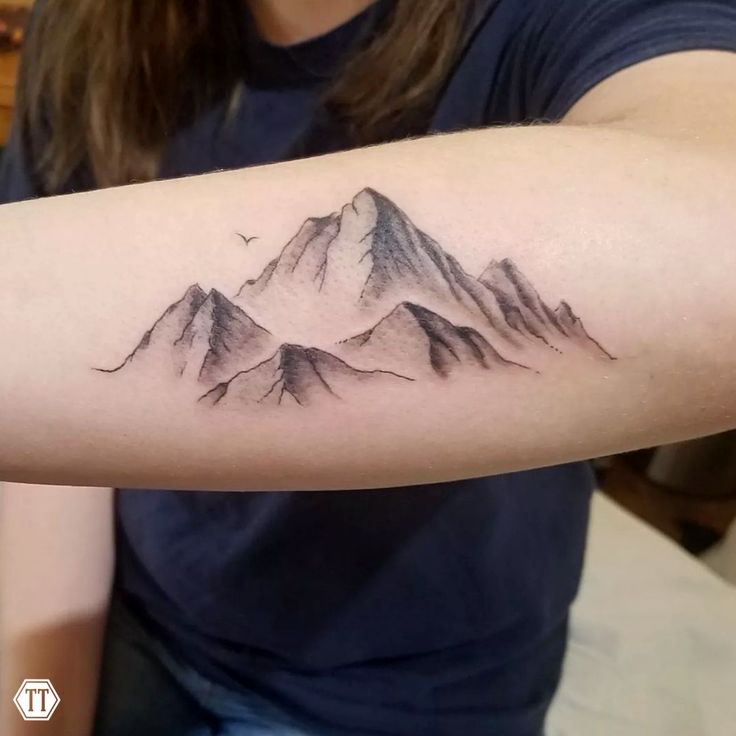 a woman with a mountain tattoo on her arm