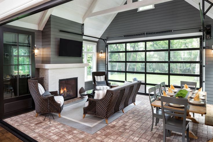 an outdoor living room with fireplace and dining table