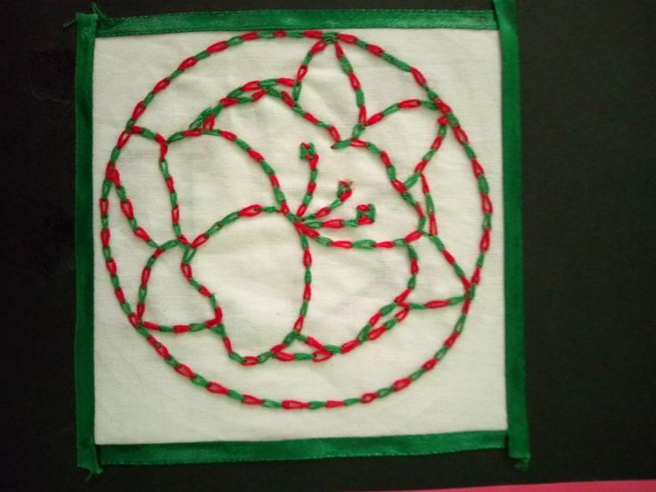 a piece of art made with red and green thread