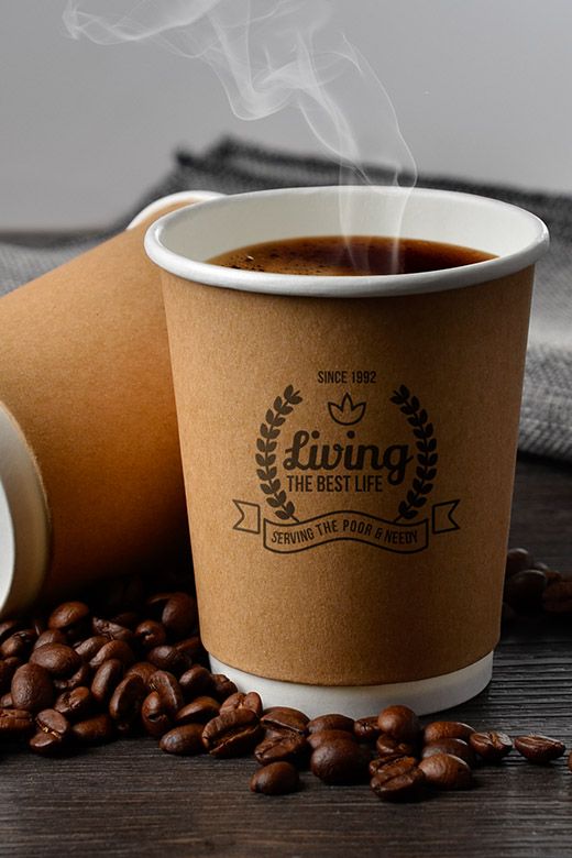 a cup of coffee sitting on top of a wooden table next to some coffee beans