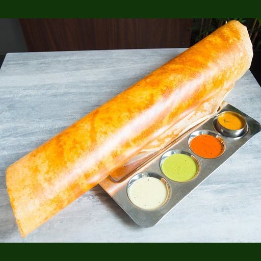 a long loaf of bread sitting on top of a pan filled with different colored sauces