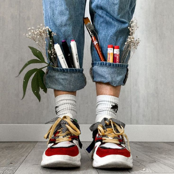 a pair of jeans and sneakers with pens, pencils, markers, and scissors in them