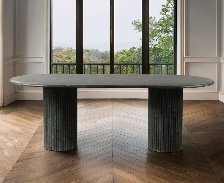 an elegant dining table in the middle of a room with wooden floors and large windows