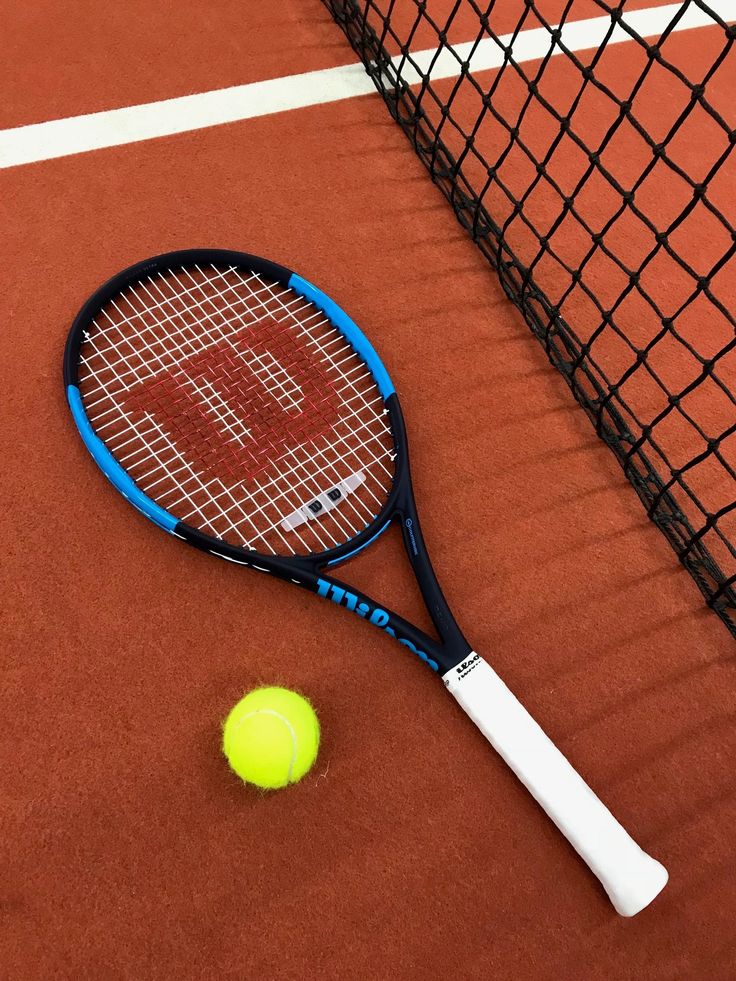 a tennis racquet and ball on a court with the word dwp painted on it