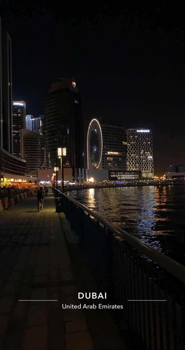 people walking along the waterfront at night in abu