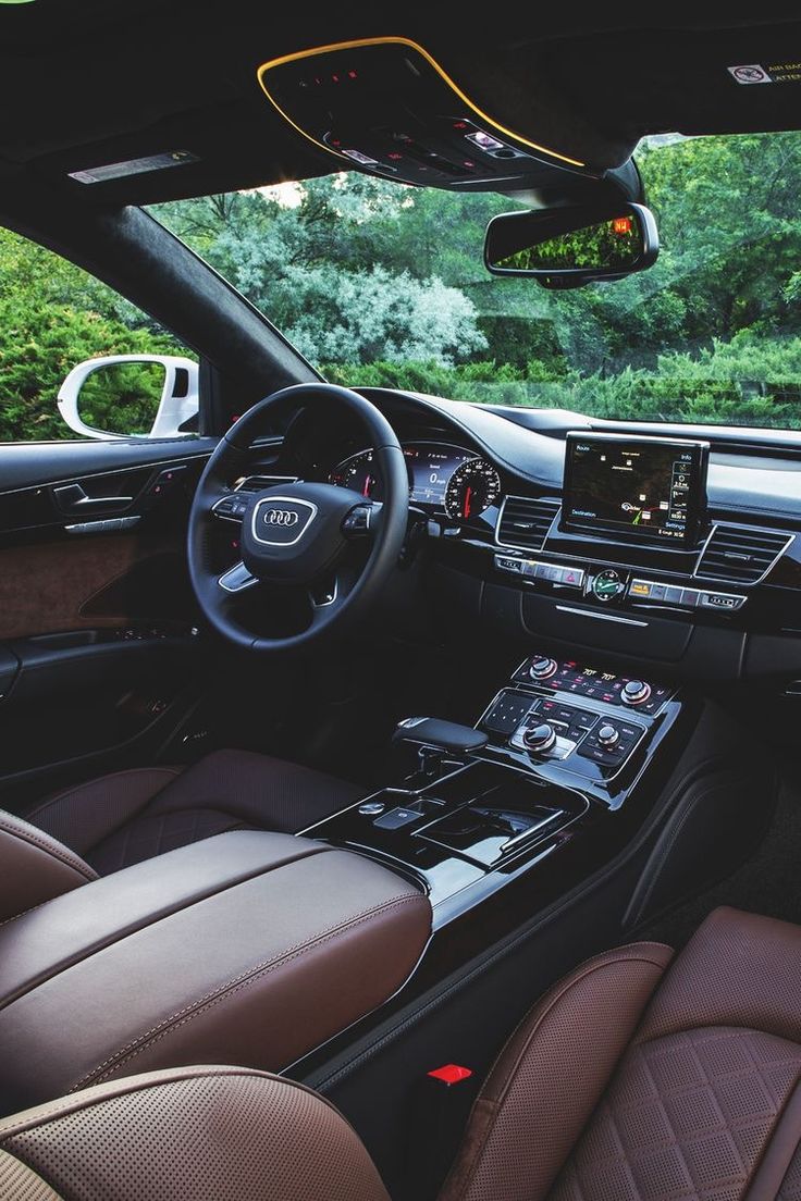 the interior of a car with brown leather seats and dashboard controls, including an electronic display