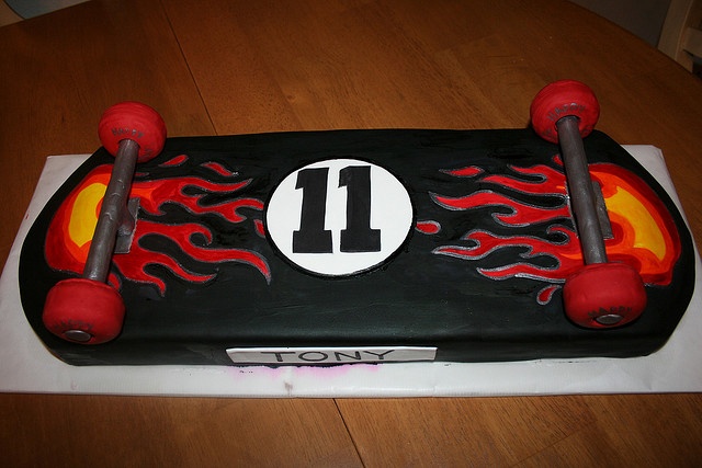 a birthday cake that looks like a skateboard with flames on it