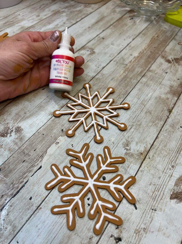 someone is making a snowflake out of gingerbread doughnuts and glue