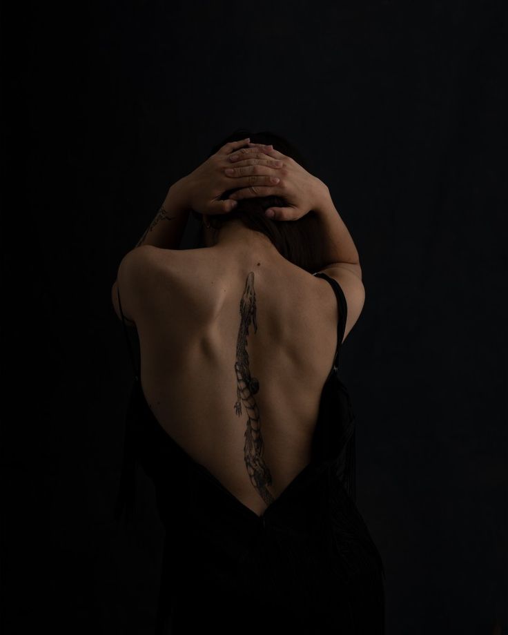 the back of a woman's body with her hands on her head and arm