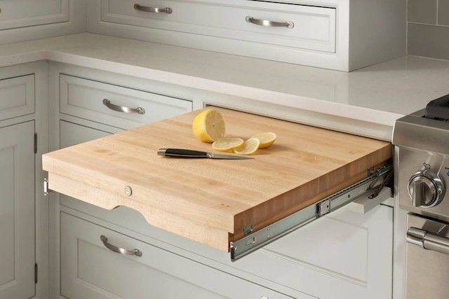 a cutting board with some lemons on top of it next to a stove in a kitchen