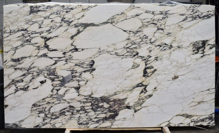 a large marble slab with white and black veining on the outside, sitting in a warehouse