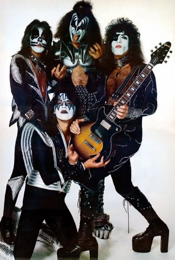 the kiss band is posing for a photo with their guitars and makeup, all dressed in black