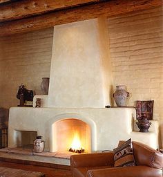 a living room filled with furniture and a fire place next to a wall mounted fireplace