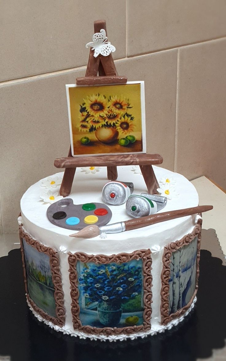 a cake decorated with an easel and painting supplies