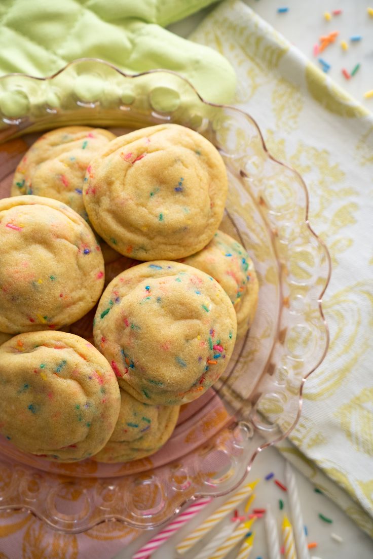 a glass plate filled with cookies and sprinkles on top of a table