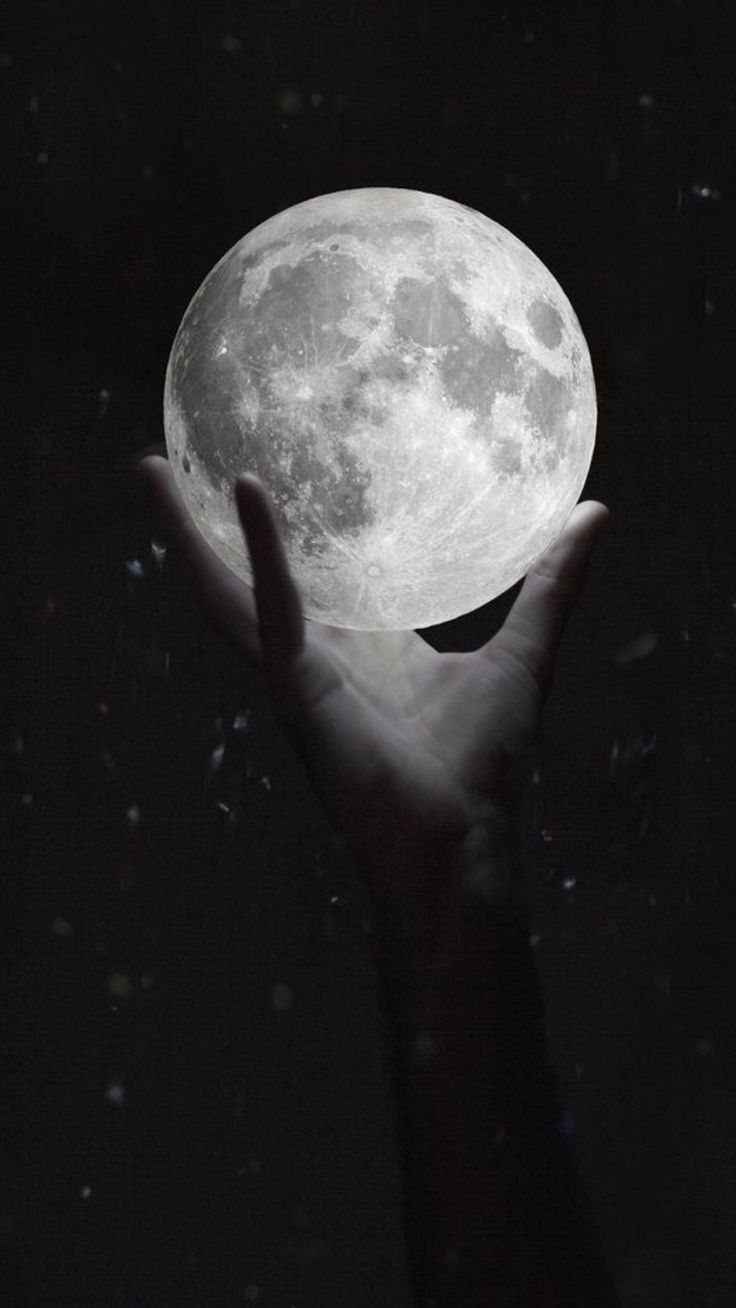 a person holding the moon in their hand