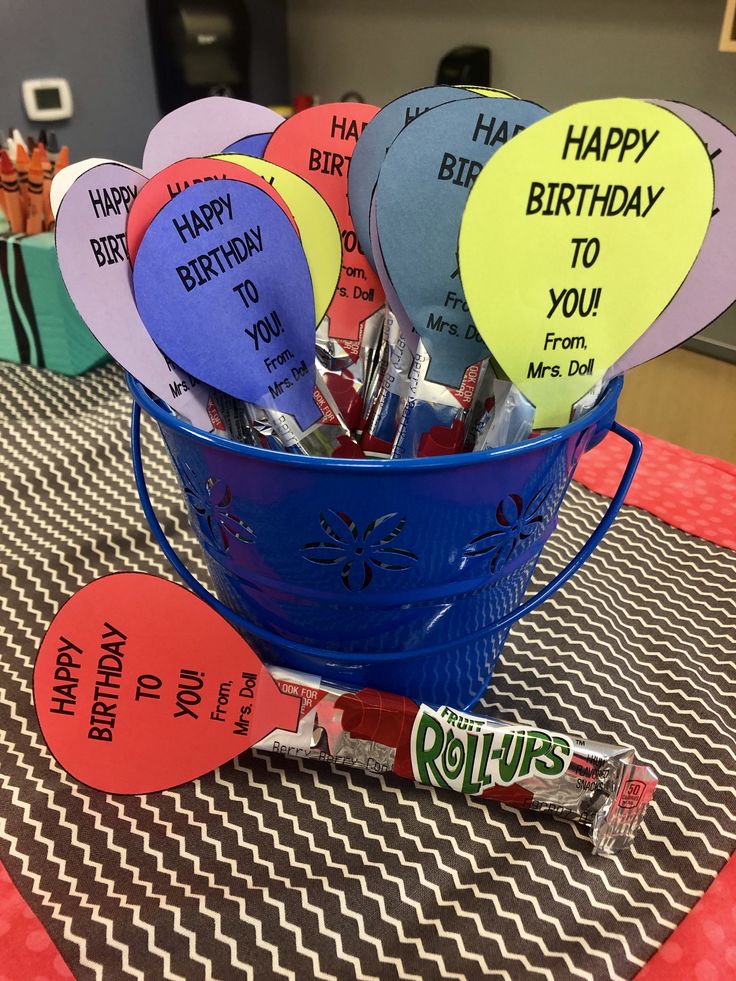 a blue bucket filled with lots of happy birthday balloons