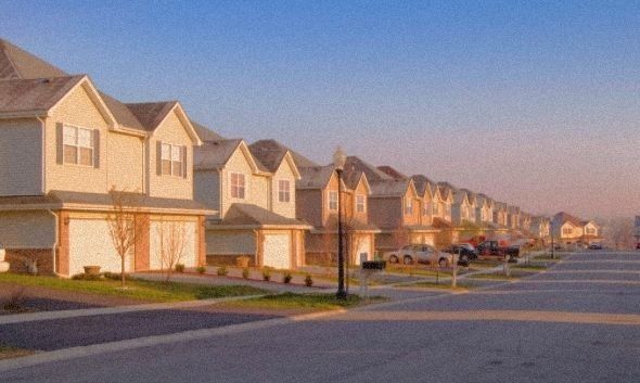 a row of houses with cars parked on the street