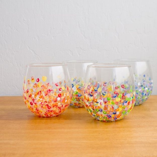 three glasses filled with colorful confetti on top of a wooden table