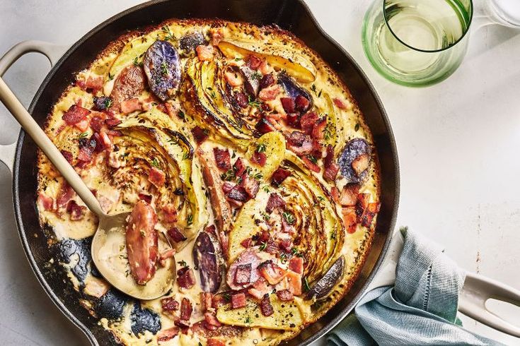 a pan filled with food and utensils on top of a white countertop