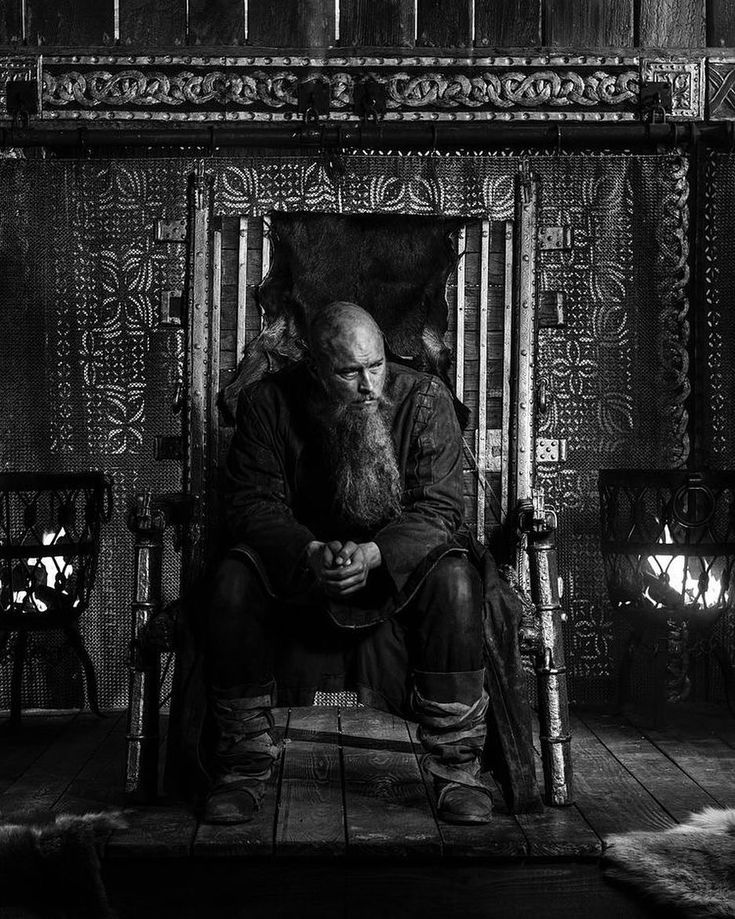 black and white photograph of an old man sitting on a throne