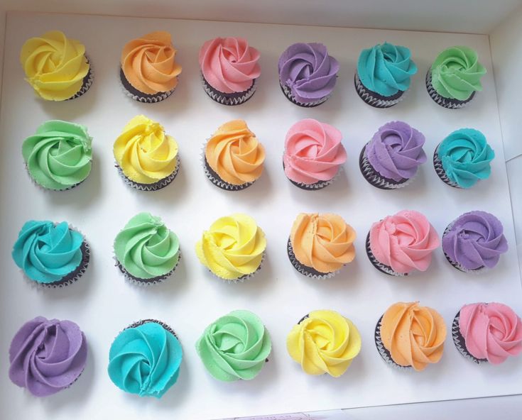 a box filled with lots of colorful cupcakes