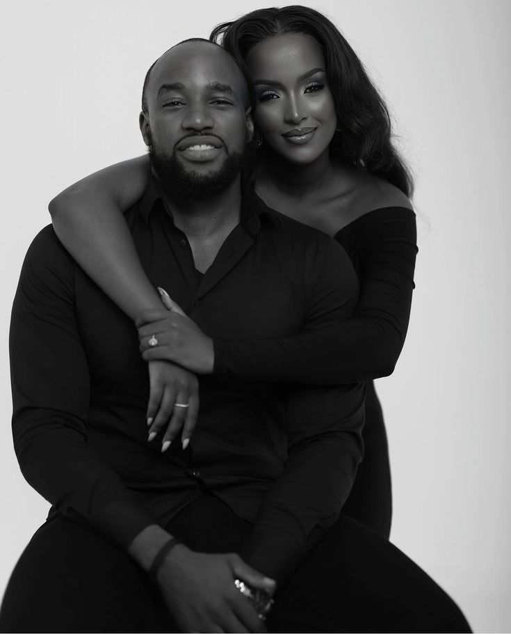 a black and white photo of two people hugging each other with their arms around one another