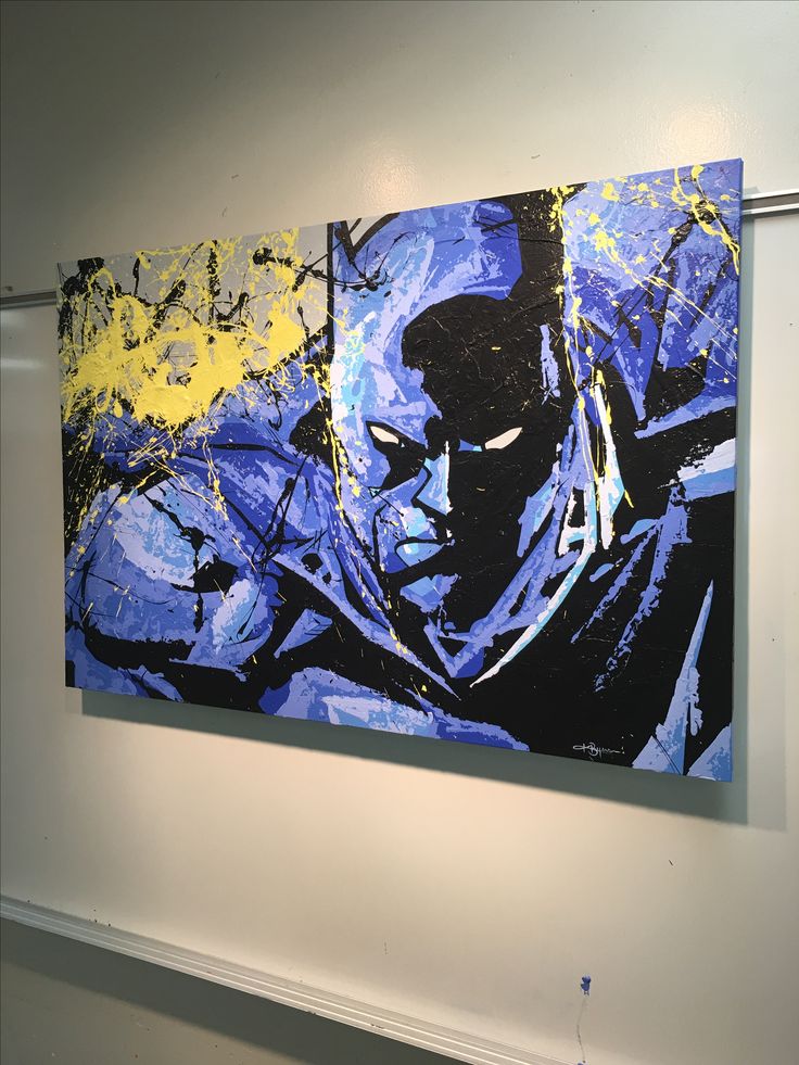 two batman paintings are hanging on the wall