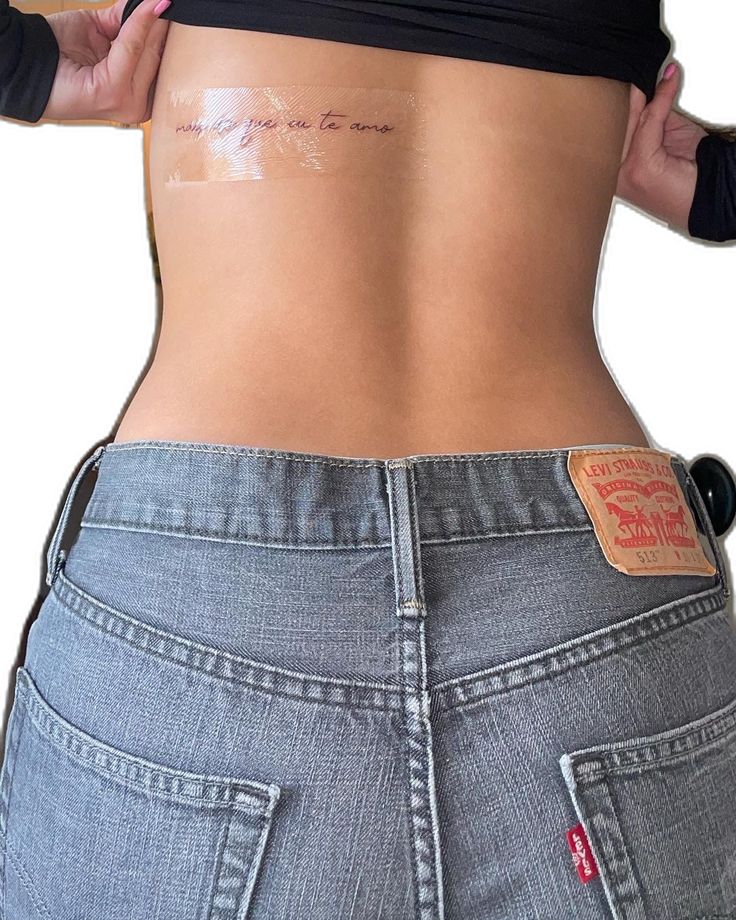 the back of a woman's stomach with tattoos on her lower body and side