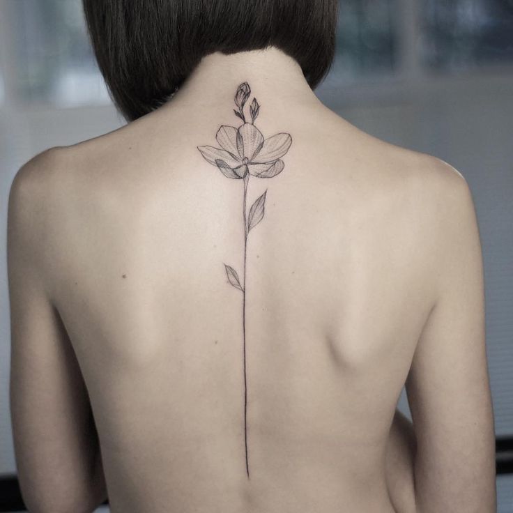 a woman with a flower tattoo on her back