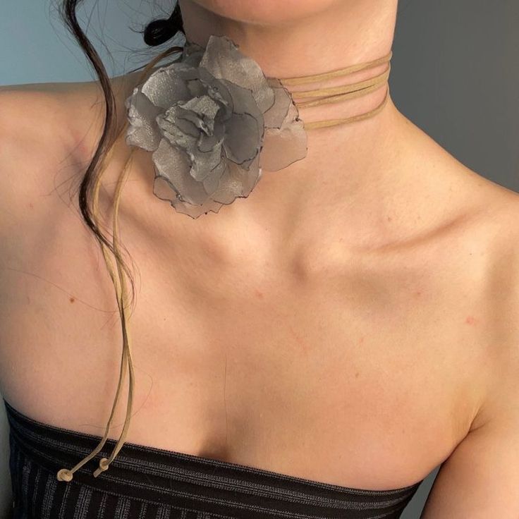 a woman wearing a strapless top with a flower on it's neckline