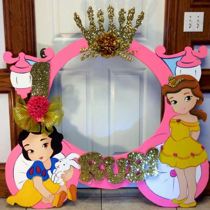 a pink frame with snow white and princesses on it, sitting in front of a door