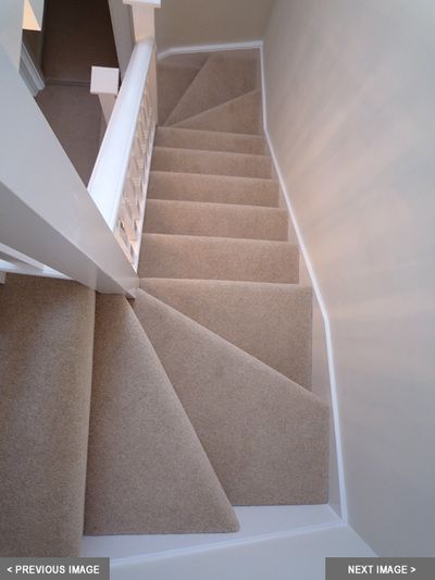 a staircase with carpeted steps leading up to the second floor