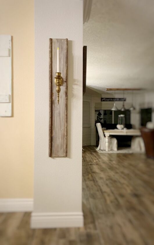 a wall mounted clock on the side of a white wall in a living room next to a dining room table