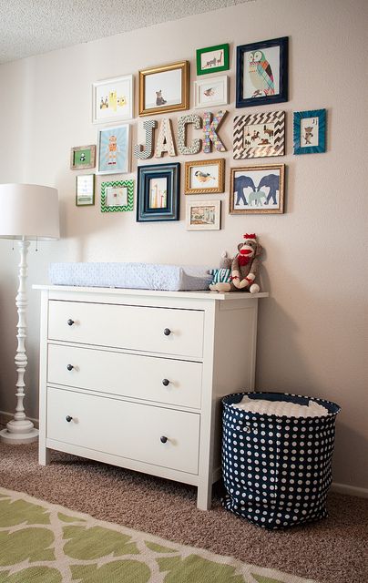 a baby's room with pictures on the wall