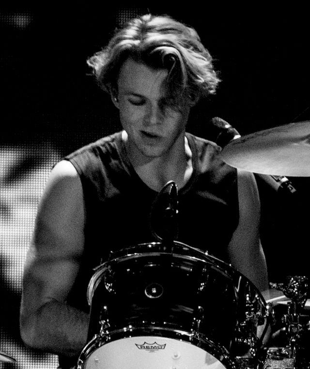 a young man is playing the drums on stage