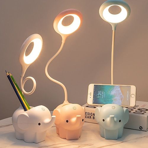 three elephant shaped lights on top of a table next to a cell phone and pencil holder