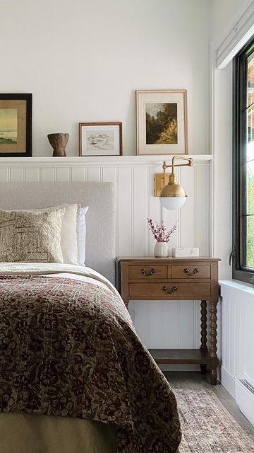 a bed sitting in a bedroom next to a window with pictures on the wall above it