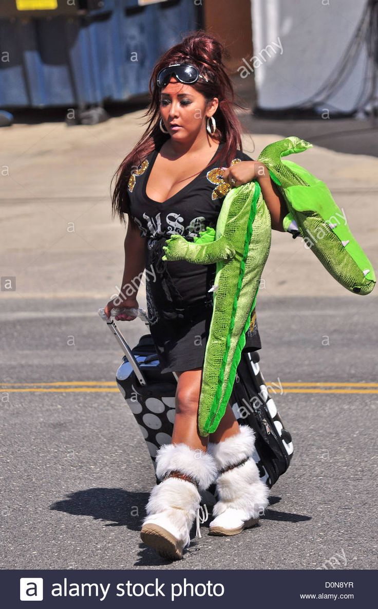 a woman in costume walking down the street with a stuffed animal on her arm and leg