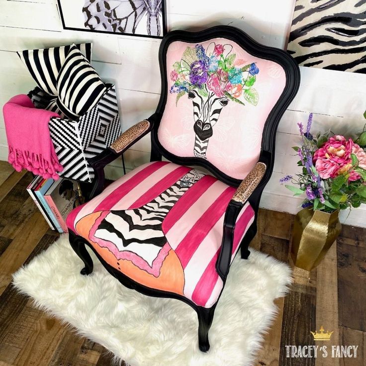 a zebra print chair sitting on top of a white rug next to a vase with flowers