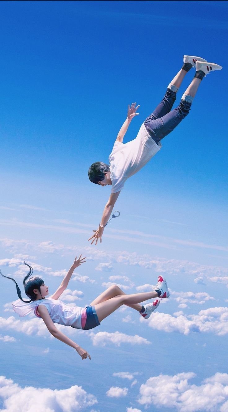 two people are flying through the air with their feet in the air and one is holding onto another person's leg