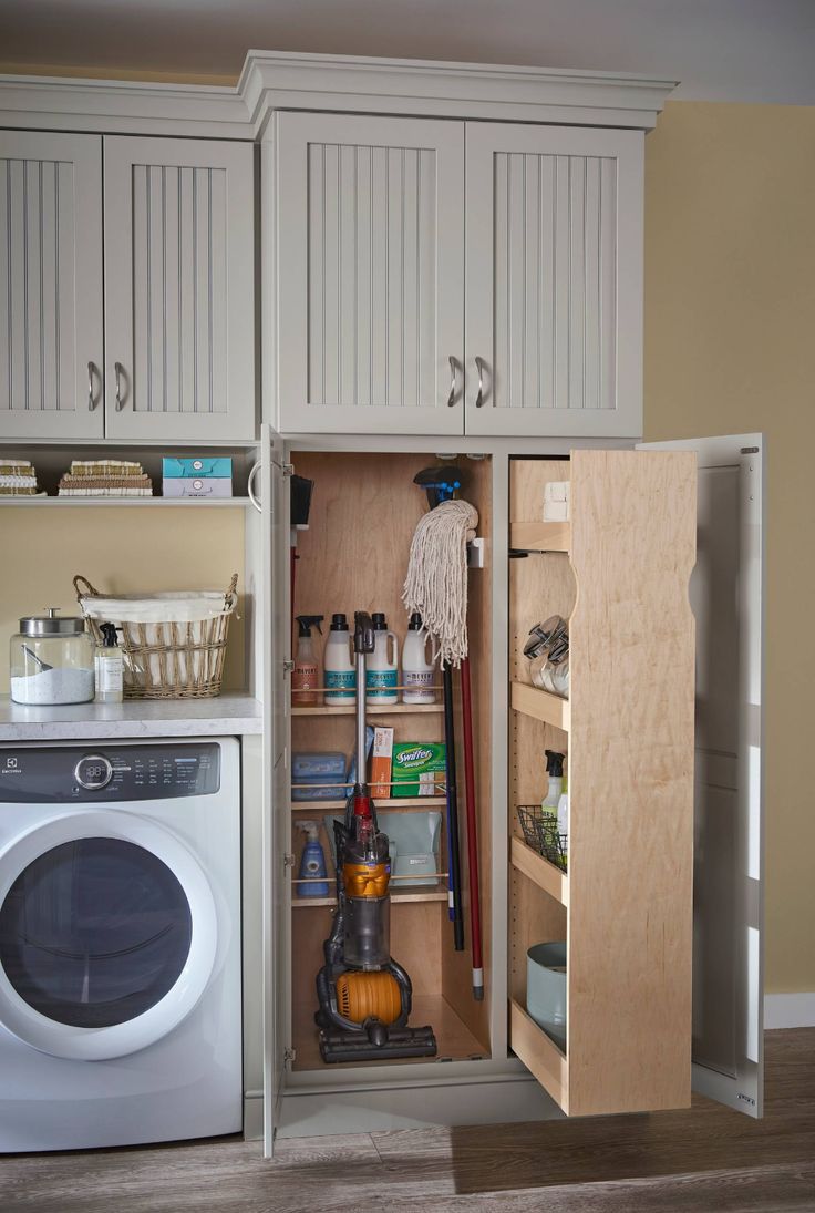 a laundry room with a washer, dryer and cabinet doors open to show the inside