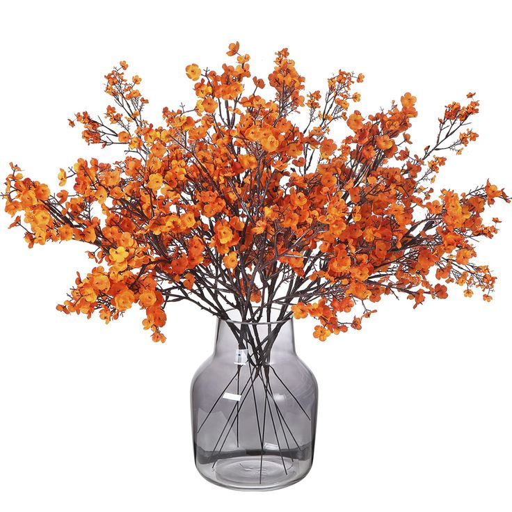 a vase filled with orange flowers on top of a table