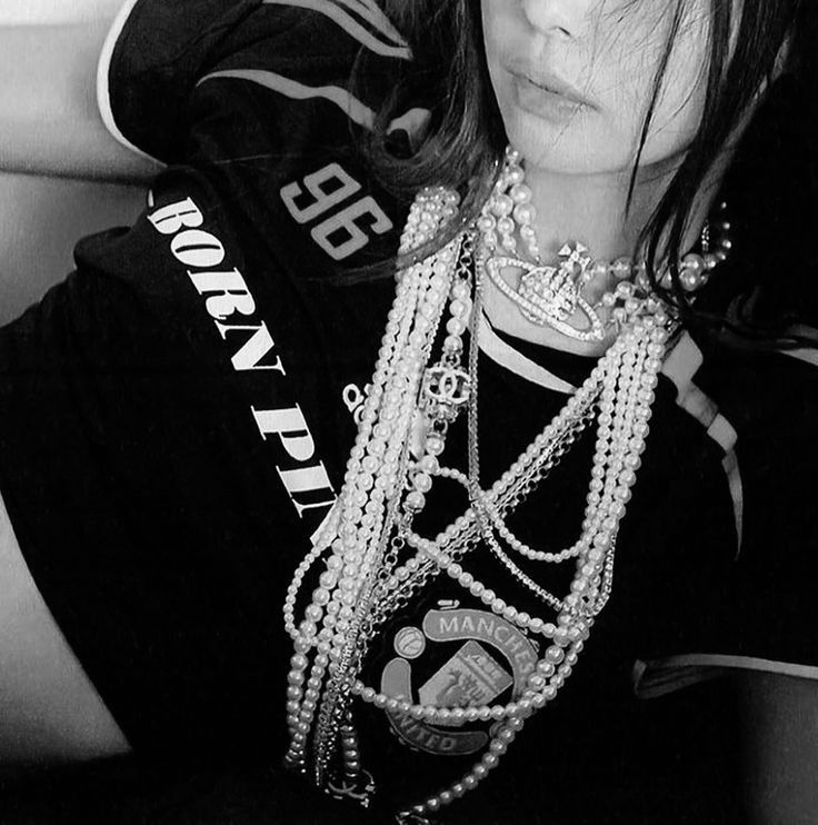 black and white photograph of a woman with pearls on her neck, wearing a t - shirt that says rock'n roll