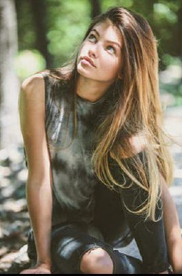 a beautiful young woman sitting on the ground