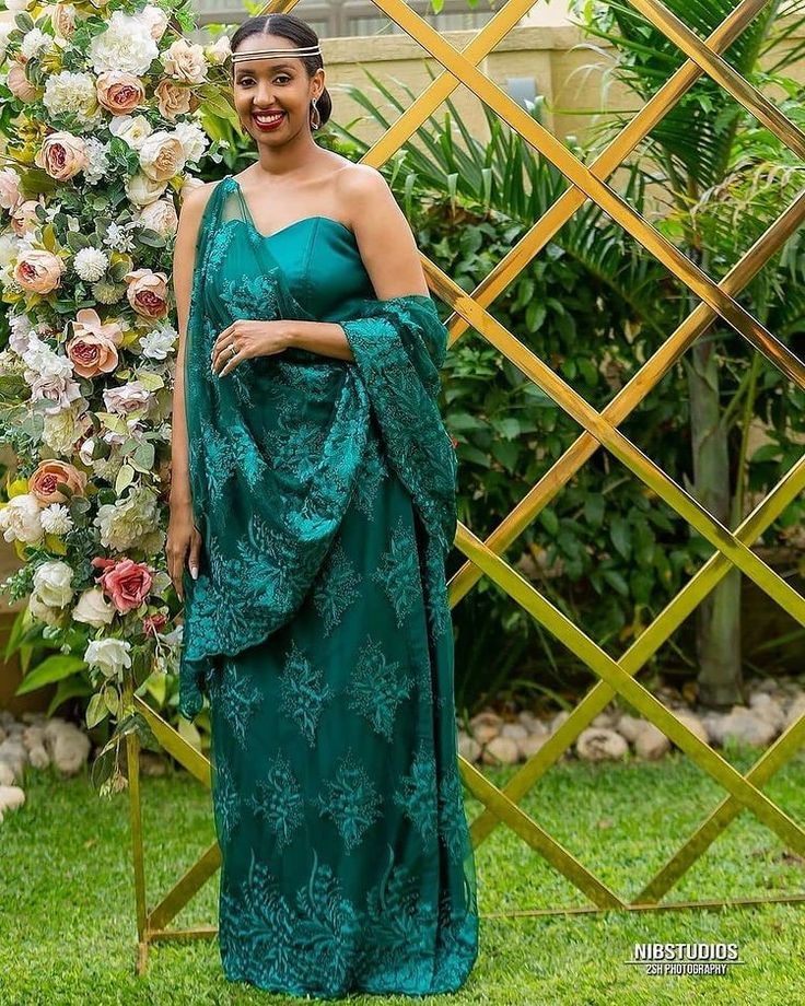 a woman standing in front of a floral arch