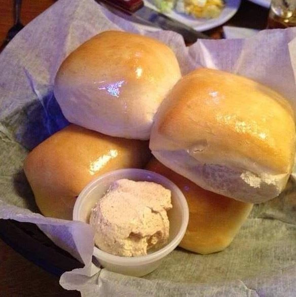 bread rolls with butter in a basket on a table