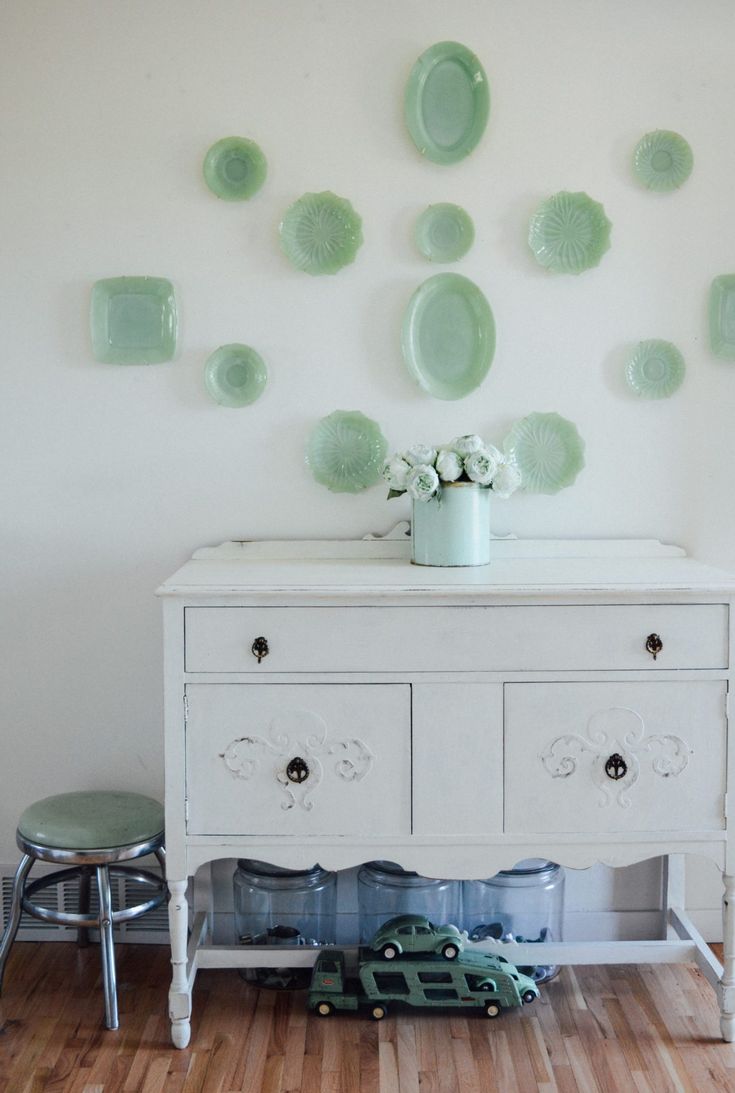 a white dresser with green plates on it