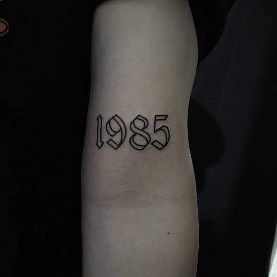 a person with a black and white tattoo on their arm that has the number 855 printed on it