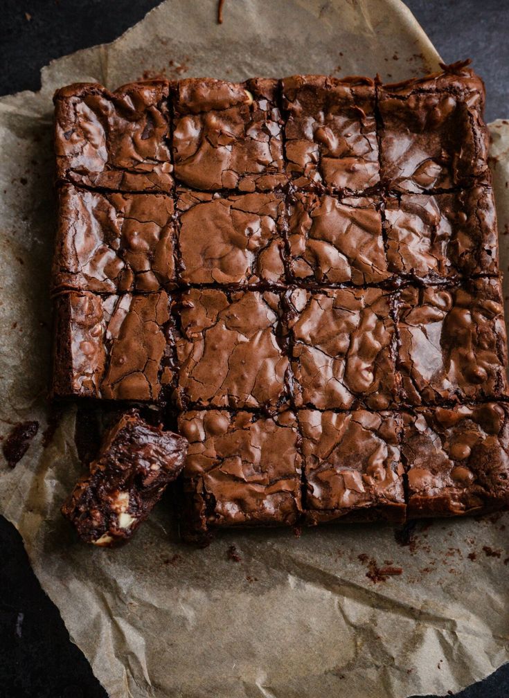 a chocolate brownie cut in half on top of wax paper